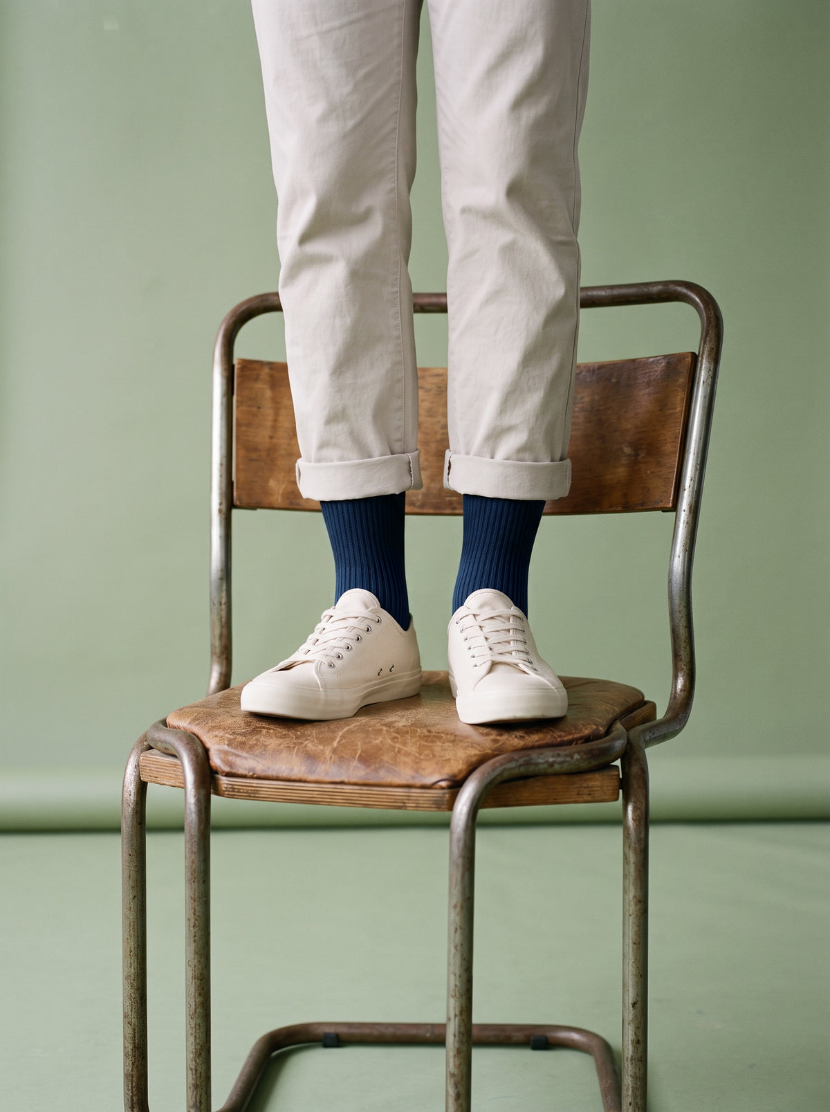 Navy ribbed crew socks with white trainers, standing on a wooden chair